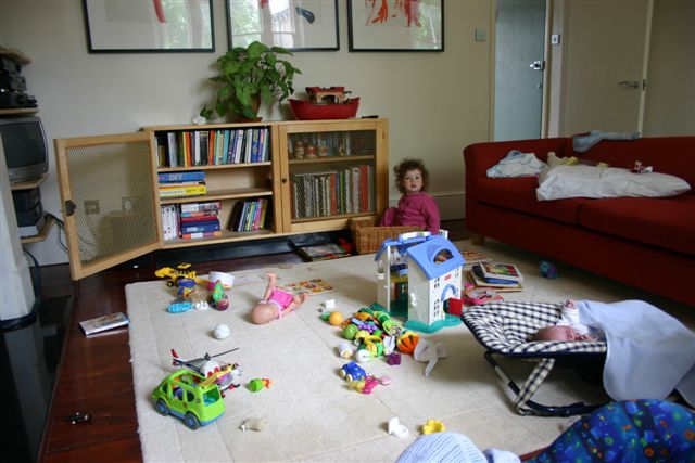 Anna (sitting in her toy basket) and Nate in living room