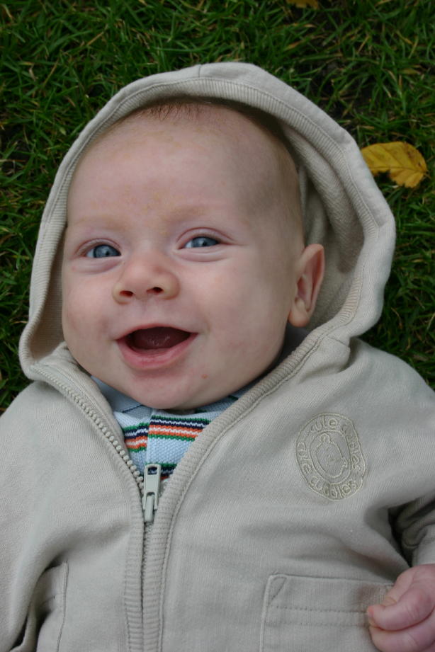 Nate lying on grass smiling