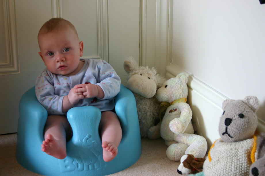 Nate siting in Bumbo in hallway at home