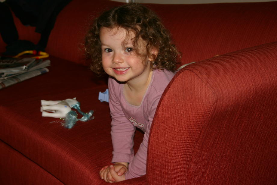 Anna peeking out from sofa smiling