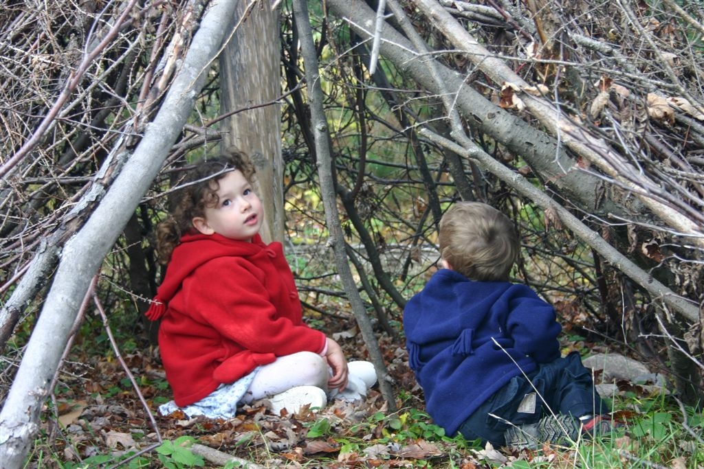 Anna and Nate sitting in a branch teepee