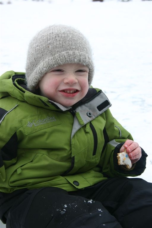 Nate outside in snow eating gingerbread man